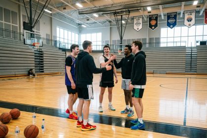 Groupe d'amis souriants sur un terrain de basket moderne